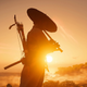 Jin Sakai plays a flute at sunset in Ghost of Tsushima on PS4.